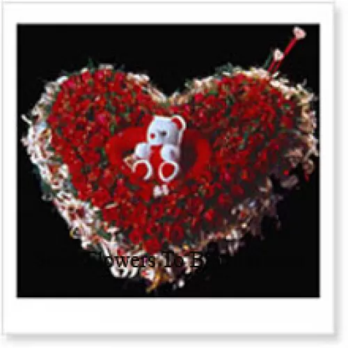 Herzförmige Anordnung von 100 roten Rosen und einem Teddybär